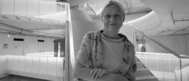 Präsidentin der Filmuni, Prof. Dr. Susanne Stürmer vor roter Treppe in Haus 6 