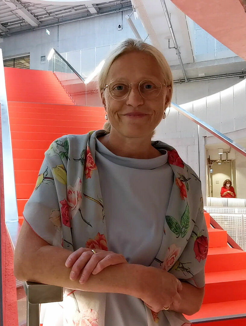 Präsidentin der Filmuni, Prof. Dr. Susanne Stürmer vor roter Treppe in Haus 6 